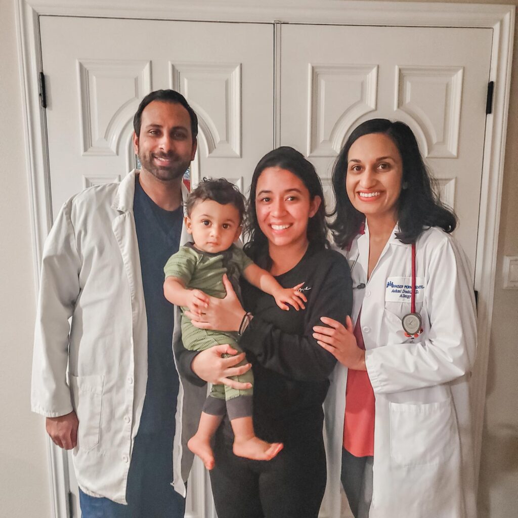 Mom and dad wearing doctors coats with au pair and toddler